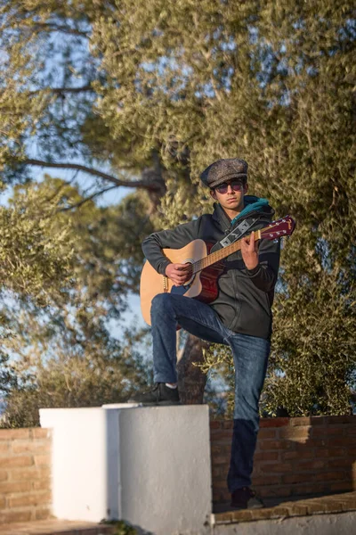 Flamenko gitar çalan gündelik kıyafetli genç adam..