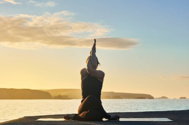 Yoga eğitimi ve meditasyon. Şafakta veya alacakaranlıkta sahilde poz vermek..