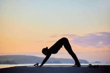 Şafak vakti, reklam için fotokopi alanı ile yoga yapan bir kadın silueti.