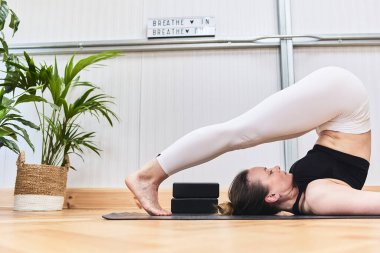 Güzel bir jimnastik salonunda çekici bir İspanyol kadınla yoga yapmanın kısmi ayrıntıları..