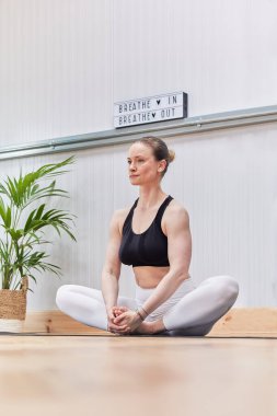 Kafkas kadın meditasyon yapıyor ve yoga ya da pilates yapıyor.