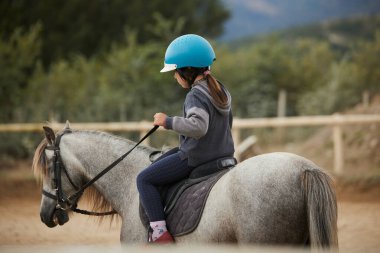 Ata binen 5 yaşında bir kız. Spor konseptine kadar şaşmaz