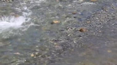 Nehirdeki taşların kıvrımlı ışıkları su altı kabarcıklarında koyu mavi delikler