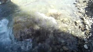 Canlı bir taşın üzerindeki su nehri Güneşli bir saatte sıçradı