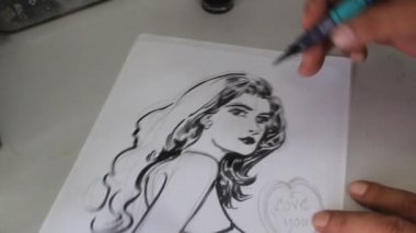 Beyaz El, karikatür çiziyor. Siyahi kadın, nefes kesici çekimde.