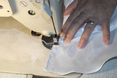 Önlük Üreticisinin Ellerine Dikiş Makinesi