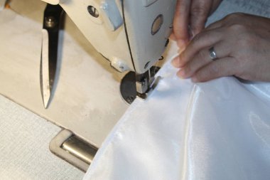 Önlük Üreticisinin Ellerine Dikiş Makinesi