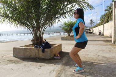 Egzersiz yaparken Deniz Kıyısındaki Kız