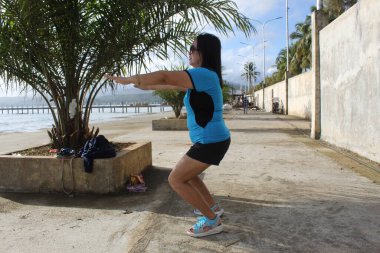 Egzersiz yaparken Deniz Kıyısındaki Kız