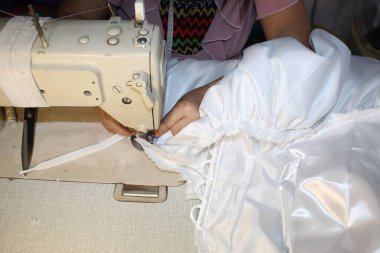 Meşgul Saat Kanalizasyon Modeli beyaz uzun bir elbise dikiyor