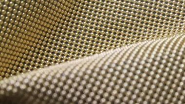 Elbise imalatçısı malzeme kanalizasyonu uzun elbiseler için altın küreler ve çiğ boncuklar üzerinde çalışır.