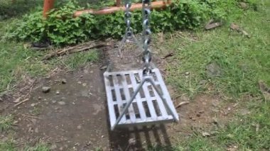Yaz mevsiminde halka açık alanda sallanan çocuk parkı koltuğu.