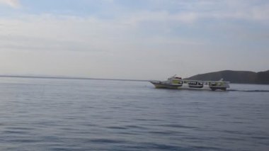 Okyanus Gezisi, dağ manzaralı bir tekneyle şehre iniyor. 