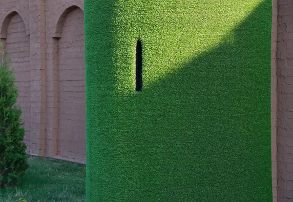 Dekorative Struktur aus gefälschtem Gras in Form eines Turms Stockbild