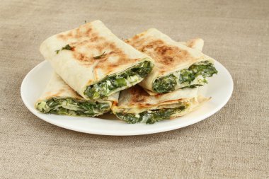 Otlar ve beyaz peynir beyaz plaka kaba keten kumaş üzerine kavrulmuş rulo ekmek silindir Mini değirmenler dolu