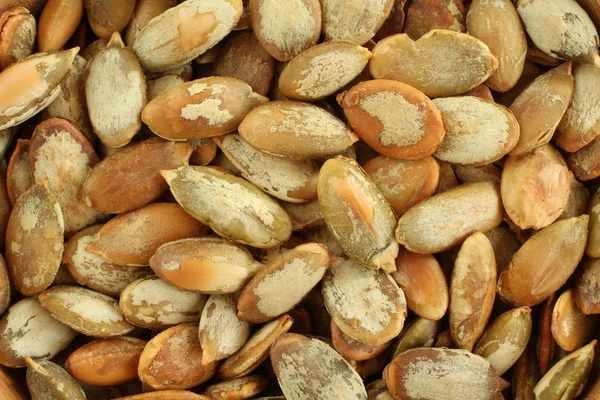 Fondo alimenticio - grandes semillas de calabaza tostadas sin cáscara — Foto de Stock