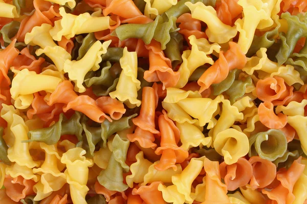 Lebensmittel Hintergrund - rohe dreifarbige Campanelle Hartweizen Pasta mit Spinat und Tomaten Stockbild