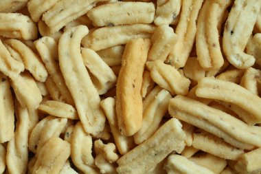 Ganthiya (kızarmış baharatlı nohut çubukları). Çubuk yığınına yukarıdan bak. Yakın çekim.