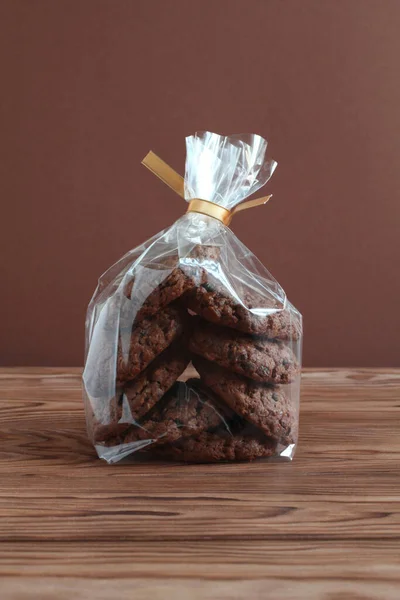 Chocolate Oatmeal Cookies Transparent Bag Wooden Table Brown Wall Closeup — Stock Photo, Image
