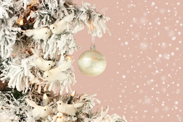 Decorazione su albero di Natale - uccelli bianchi e palla d'argento su abete rosso innevato su sfondo rosa — Foto Stock