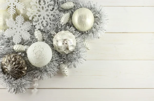 Decoración de Navidad - bolas blancas y plateadas, conos de plata, copos de nieve blancos, guirnalda de plata sobre fondo de madera blanca —  Fotos de Stock