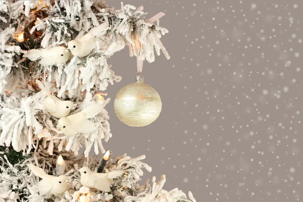 Decorazione su albero di Natale - uccelli bianchi e palla d'argento su abete rosso innevato su sfondo grigio chiaro — Foto Stock