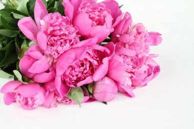 Beyaz boyalı ahşap zemin üzerinde küçük pembe peonies buket