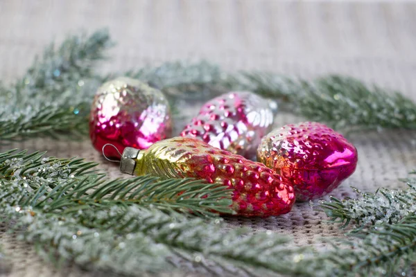 Oude sovjet decoratie op de kerstboom, glazen speelgoed aardbei en dennenappel close-up op gebreide achtergrond — Stockfoto