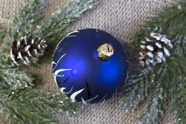 Bola de Natal azul bonita com padrões em um fundo de malha luz acolhedora, close-up — Fotografia de Stock