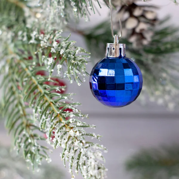 Mooie blauwe kerstbal met patronen in op een gezellige lichte achtergrond met kerstboom, close-up — Stockfoto