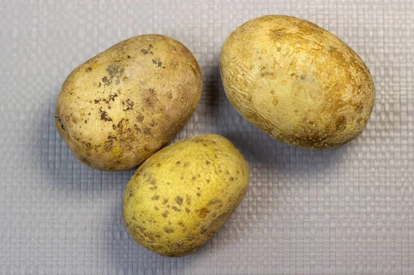Варена жовта картопля в куртках на фоні легкої текстури, крупним планом — стокове фото