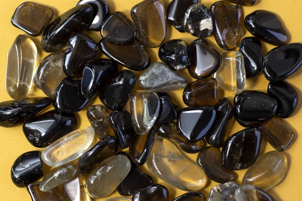 Macro tiro de colección conjunto de roca natural de morión, cristales de cuarzo ahumado gema piedras minerales sobre fondo naranja — Foto de Stock