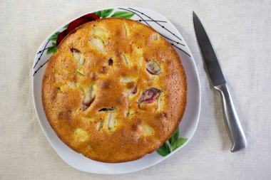 İştah açıcı elma erikleri beyaz tabakta turtalar keten arka planda, yakın plan