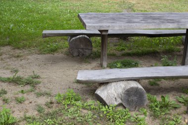 Eski ahşap bank ve sert, yuvarlak kerestelerden yapılmış masa, açık hava eğlencesi.