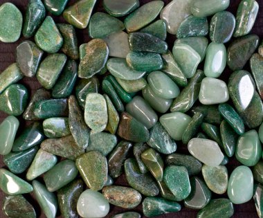 Doğal mineral kaya örneğinin makroskobu - siyah arka planda yuvarlanan yeşil bulvar taşı
