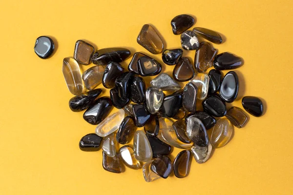 Макросъемка коллекции натуральных скальных комплектов морионов, дымовых кварцевых минеральных камней на желтом фоне — стоковое фото