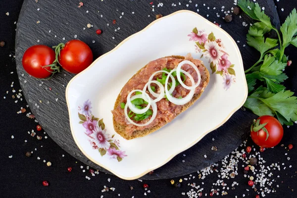 Domuz kıymalı çörekler soğanlı sosis ve maydanozla kahvaltı masasında tahta tahtayla.