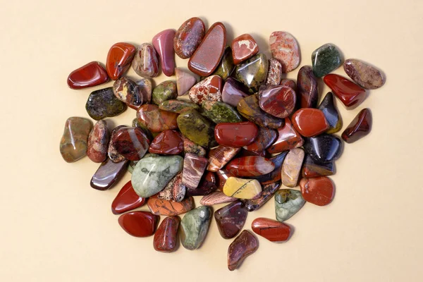 Красный и разноцветный яшмень полированные камнями на светло-бежевом фоне — стоковое фото
