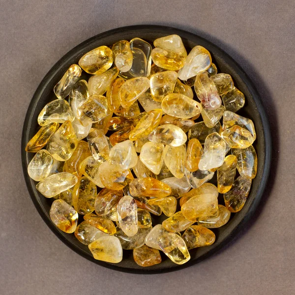 Citrine yellow gem geode crystals geological mineral on black plate and grey linen as nice background close up — Stock Photo, Image