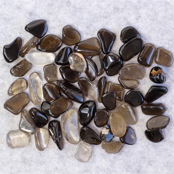Macro tiro de colección conjunto de roca natural de morión, piedras minerales de gema de cuarzo ahumado sobre fondo gris claro — Foto de Stock