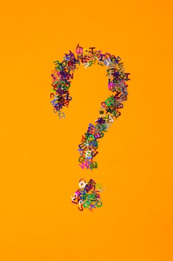 Kırmızı arkaplanda çok renkli küçük harfler dağılmış soru işareti