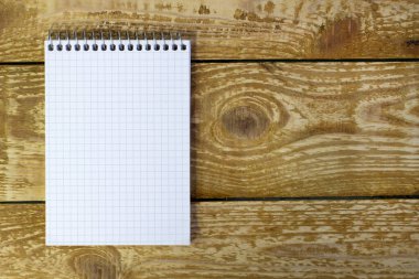 Kahverengi ahşap desenli arka plan görünümüne yazmak için boş alanı olan beyaz yay not defteri