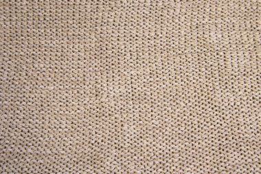 Soyut, güzel örülmüş bir arka plan. Açık gri ya da bej renkli yün süveter dokusu. Örgü desenli resmi kapat