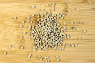 Tahta bambu arka planda beyaz biberli mısır, geleneksel baharatlar. Yakın plan. seçici odak