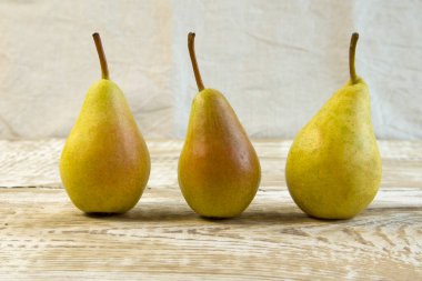 Gri ahşap arka planda sulu, olgun, sarı bir armut. Yakın plan ön plan, durgun hayat.