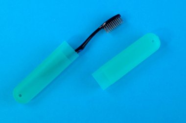 Kapalı profil makro görünümü fotoğrafı. Plastik tribün kapağında parlak mavi arka planda siyah diş fırçası ile paketlenmiş.