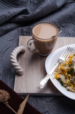 Tahta tahtada pişirilmiş sıcak kahve fincanı ve kahvaltı. Lezzetli kurabiyelerle bej arka planda bir fincan lezzetli kahve. Amerikan kahvesi ve beyaz böğürtlenli kurabiye. Beyaz kahve kupası.