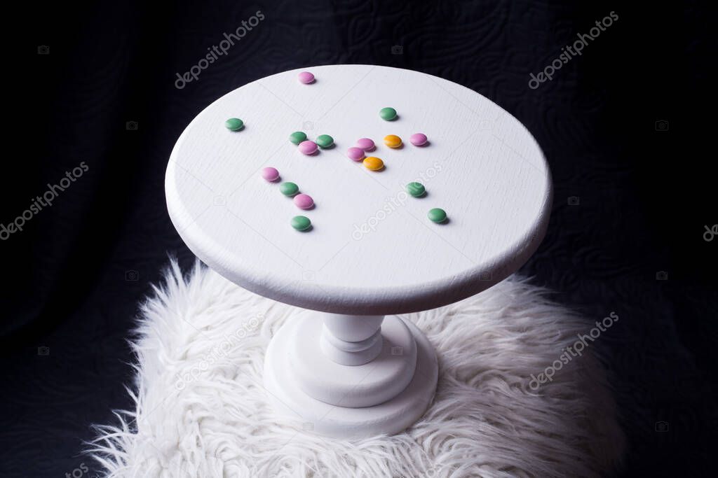 colorful chocolate buttons M MS on a wooden white stand