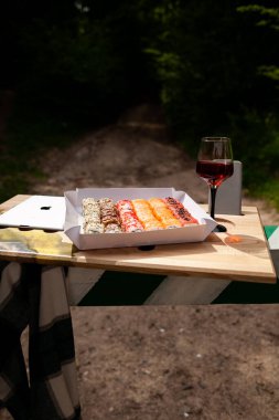 Lezzetli renkli suşi ruloları ve doğada bir bardak beyaz