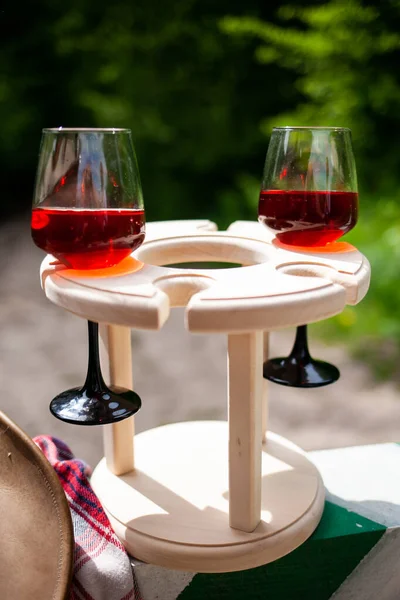pair of wine goblets and cowboy hat on the barrier in the reserve. Picnic in nature.
